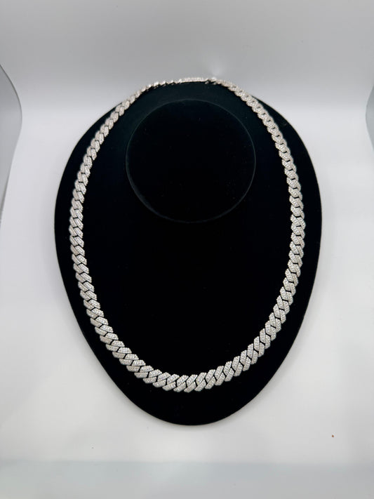 Silver chain necklace on a black stand against a white background