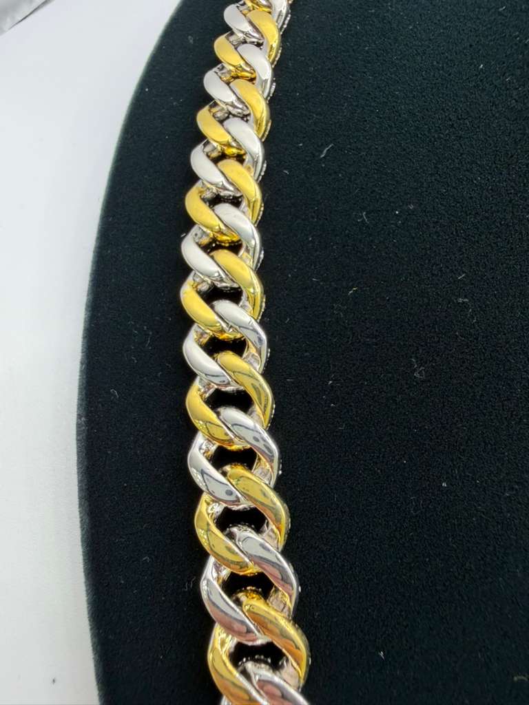 Two-tone gold and silver chain on a black and white background